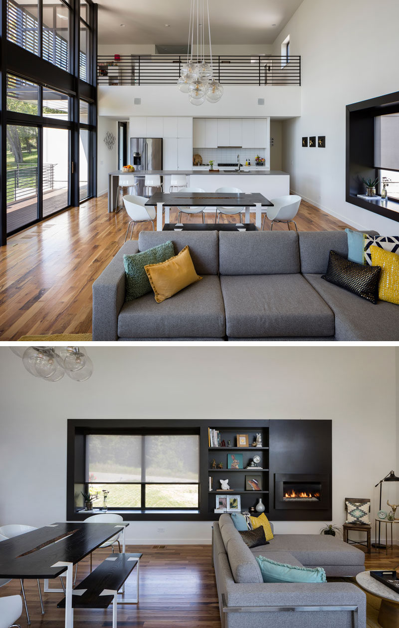 This modern house has an open plan living area with a black framed window seat with open shelving and a fireplace built into the wall.