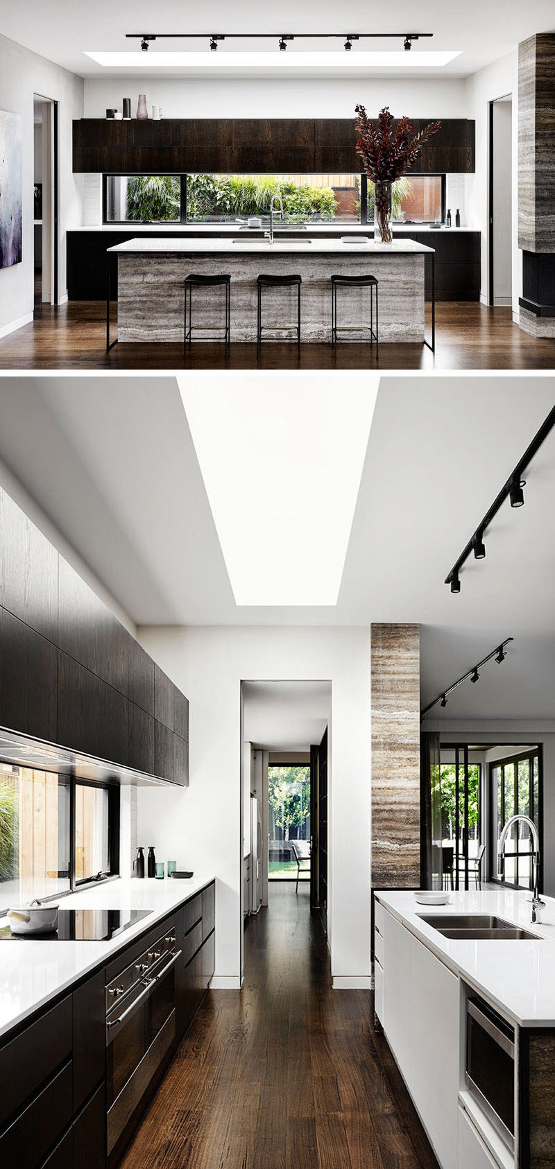 This modern kitchen features a large island with a stone base that matches the fireplace, and provides an ample amount of counter space for food preparation, while the white countertops provide a contrast the dark cabinets.