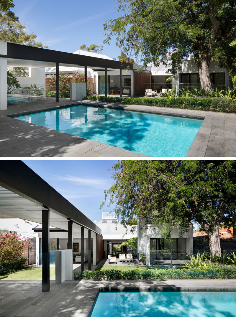 Next to the outdoor kitchen and dining area in this modern backyard is the swimming pool. A glass safety fence surrounds the pool and allows for uninterrupted views of the backyard.