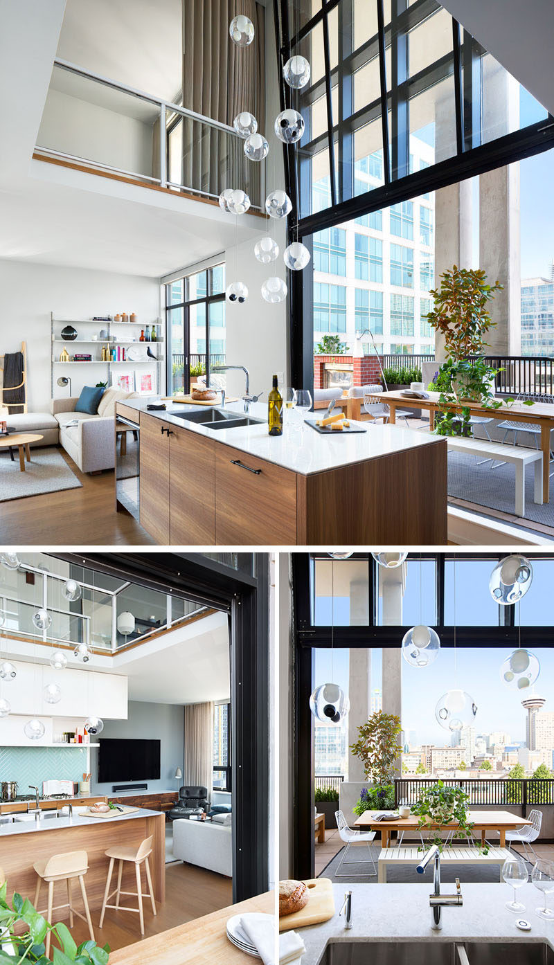 The main living area of this loft has large black framed windows that lift up to open the interior to the large balcony outside.