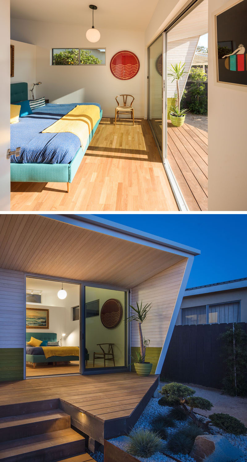 This modern master bedroom has sliding glass doors open up to a deck that looks out to the backyard.