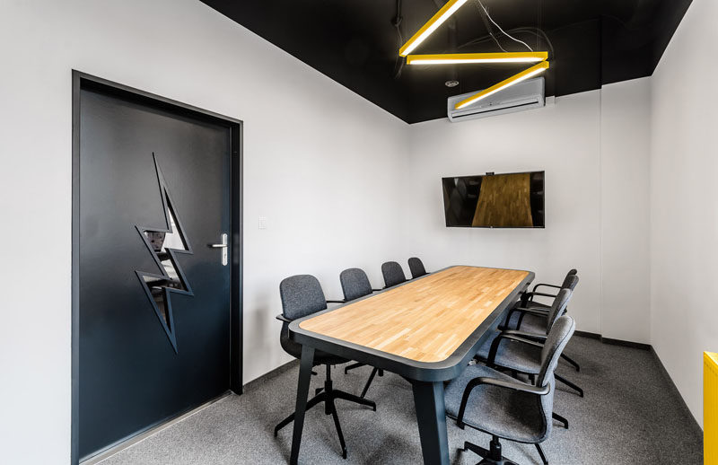 In this modern office, lightning bolt inspired elements can be found in the boardroom with the overhead lighting and the window shape in the door.