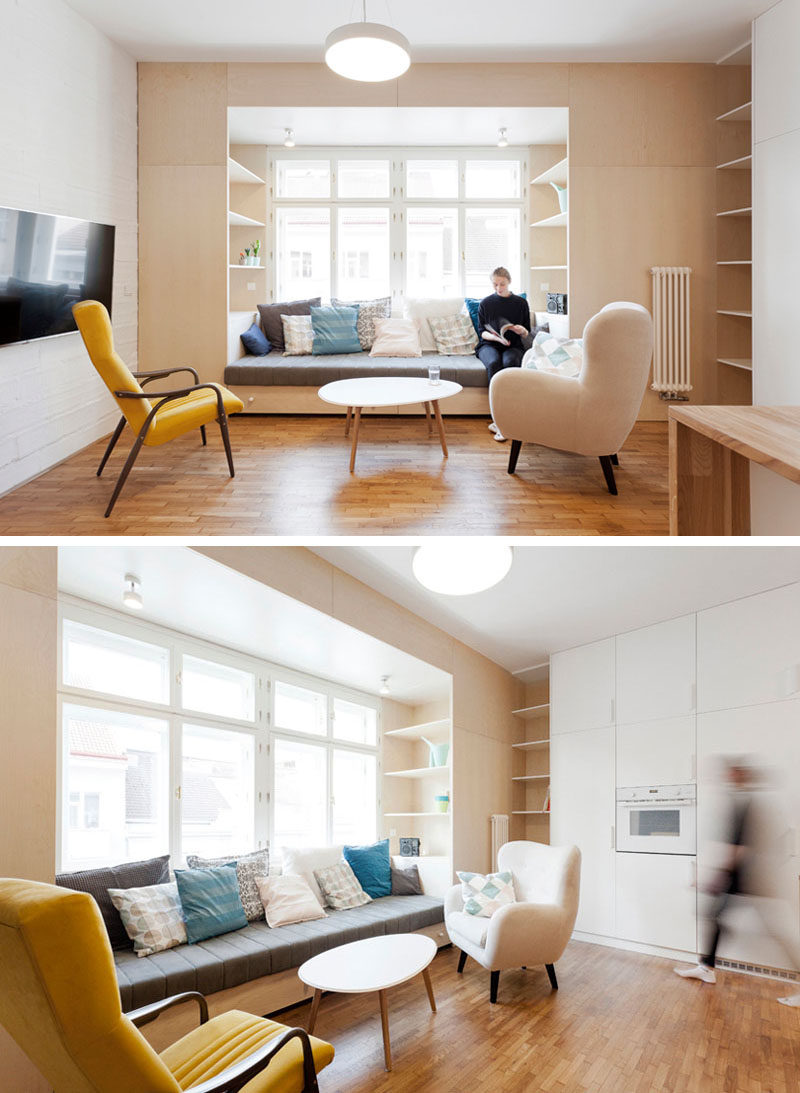 Instead of buying furniture separately and having an odd space in the living and kitchen area of this apartment, the designers created a dedicated space for lounging by using wood to create a built-in couch and shelving. #Couch #LivingRoom #InteriorDesign #BuiltInCouch #Sofa #BuiltInFurniture