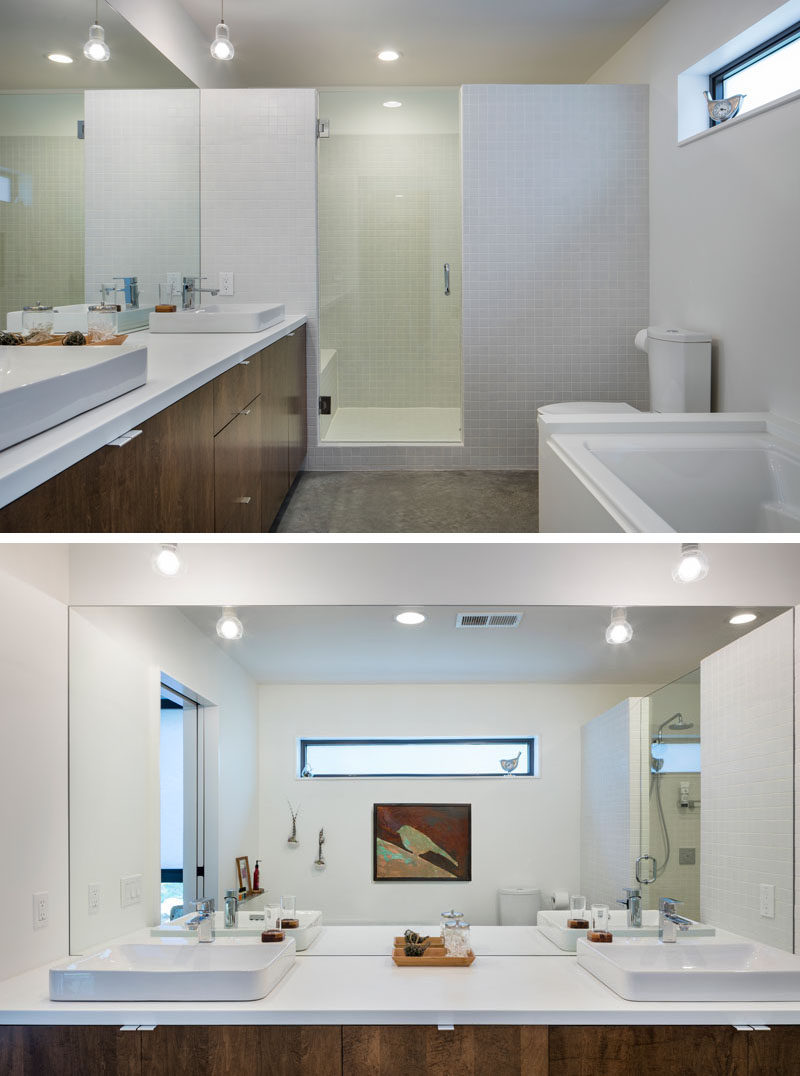 In this master bathroom there's a large vanity with dual sinks and plenty of storage, while a glass door and partial wall separates the shower from the rest of the space.