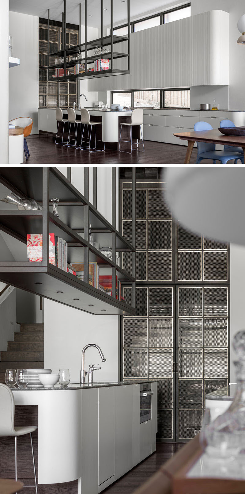 This modern kitchen, which sits next to the dining room, has white minimalist cabinets, with darker sections for seating. The upper cabinets against the wall have V grooved doors, making the joints barely visible, while a dark stone countertop contrasts the cabinets. The fridges and pantry have been hidden behind a brass and bronze woven mesh screen at the end of the kitchen.