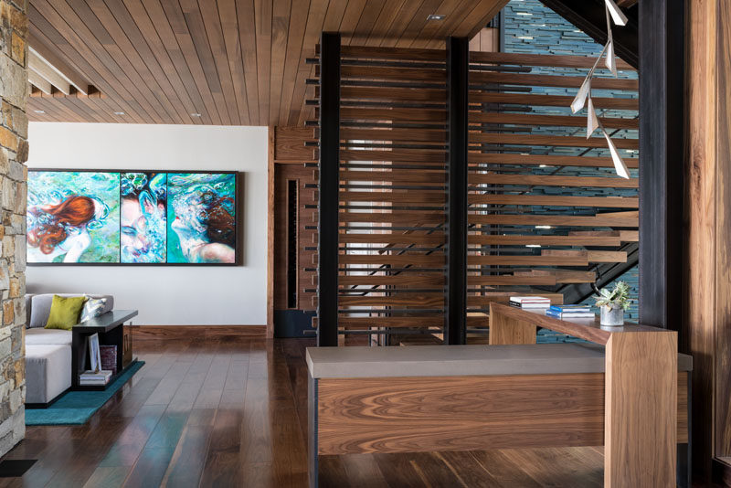 Wood and black steel stairs lead up to the upper floor of this modern lakeside club house. 