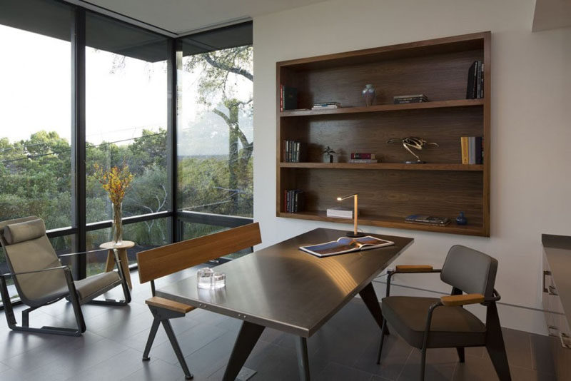 The built-in bookshelf in this modern home office has been lined with wood to tie in with the desk and flooring. #shelving #BuiltInShelving #WoodLinedShelving #WoodLinedBookshelf