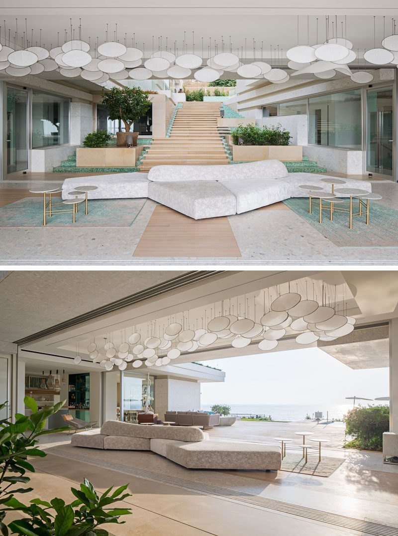 The reception area of this modern beach house has an artistic ceiling installation, opens up to a large entertaining deck and swimming pool. The flooring is recomposed marble by Quarella with natural wood inserts. #InteriorDesign #ReceptionArea #CeilingInstallation #Flooring
