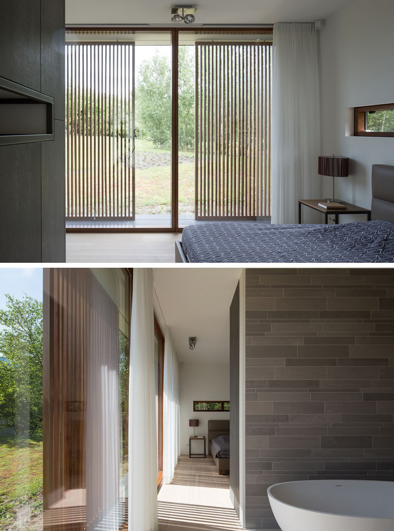 A simple color palette of blue, grey and white creates a contemporary and relaxed environment for this modern bedroom and ensuite bathroom. #ModernBedroom #WoodScreens #BathroomDesign #Windows