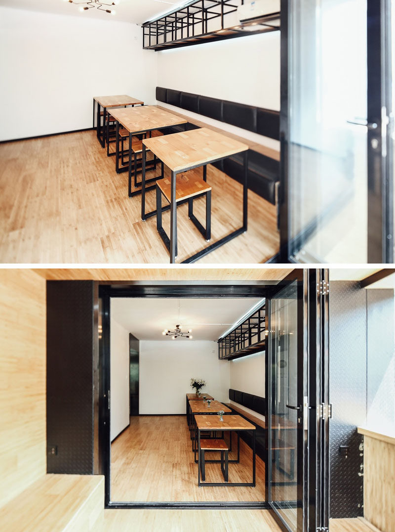 Around the corner from the bar area in this modern coffee shop, is a casual sitting room with a built-in bench running along the wall and small tables with stools. #CoffeeShop #Cafe #ModernCoffeeShop #RetailDesign #InteriorDesign