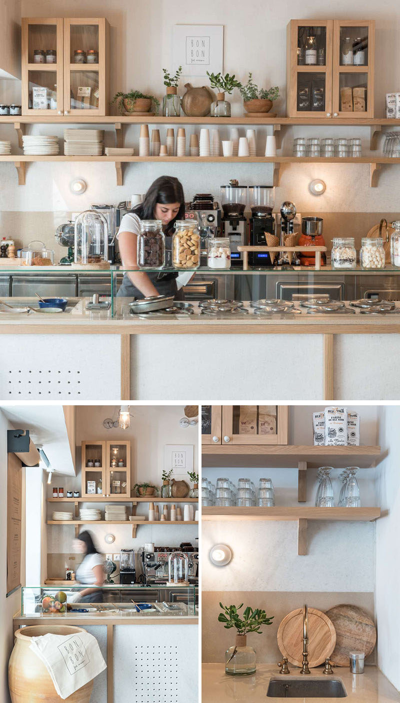 A wood and white color palette has been used throughout this modern cafe with simple wood shelves and cabinets providing storage for the variety of plates and cups. #Cafe #CafeInterior #RetailDesign #InteriorDesign