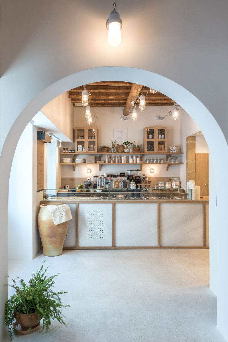 The careful selection of materials and elements in this cafe, such as the traditional mosaic floor, the white marble from the island of Naxos, the built-in benches and the wooden ceiling which was carefully restored and preserved, are familiar images tied to Greek island houses. #ModernCafe #CafeInterior #CafeDesign #InteriorDesign #Greece