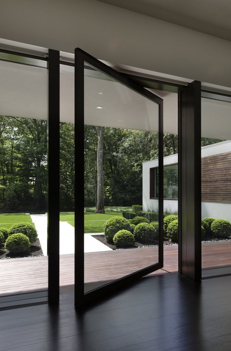 This large black-framed, pivoting glass door provides access to the backyard without blocking the view. #PivotingGlassDoor #Door #PivotingDoor