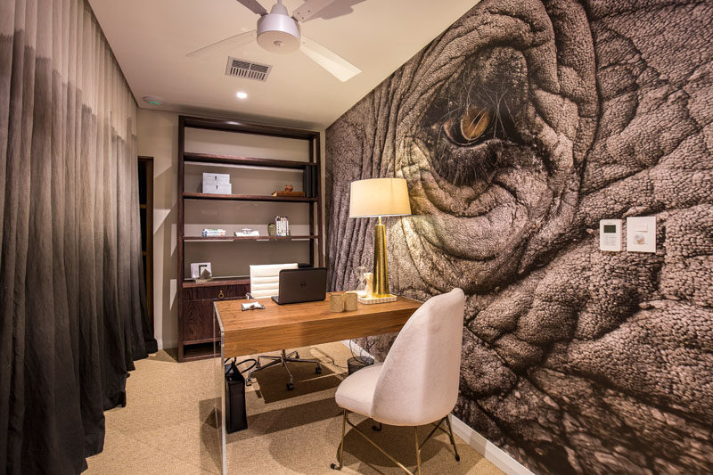 In this modern home office, a large animal mural fills an entire wall, while the curtains on the opposite wall compliment the colors found in the mural. #Mural #AnimalMural #HomeOffice #ModernInteriorDesign