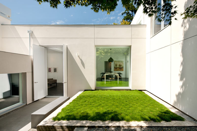 A small courtyard with grassy patch welcomes you to this modern house. #Landscaping #Architecture