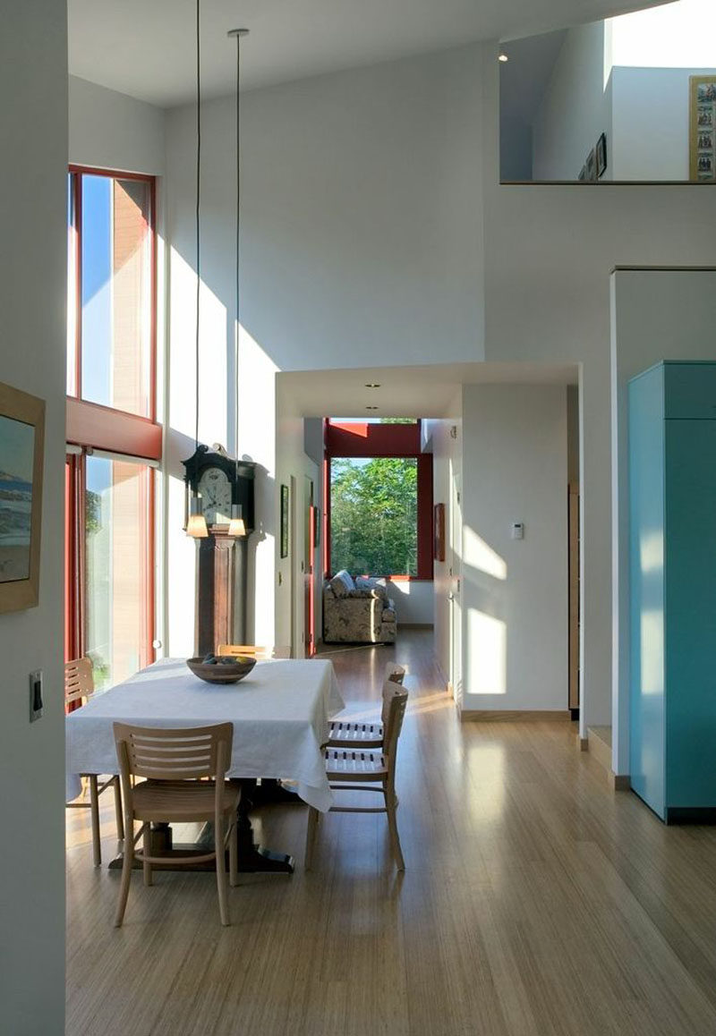 Stepping inside this modern house, the interior of the home is lofty with double-height ceilings and white walls. #ModernHouse #HighCeilings #DiningRoom