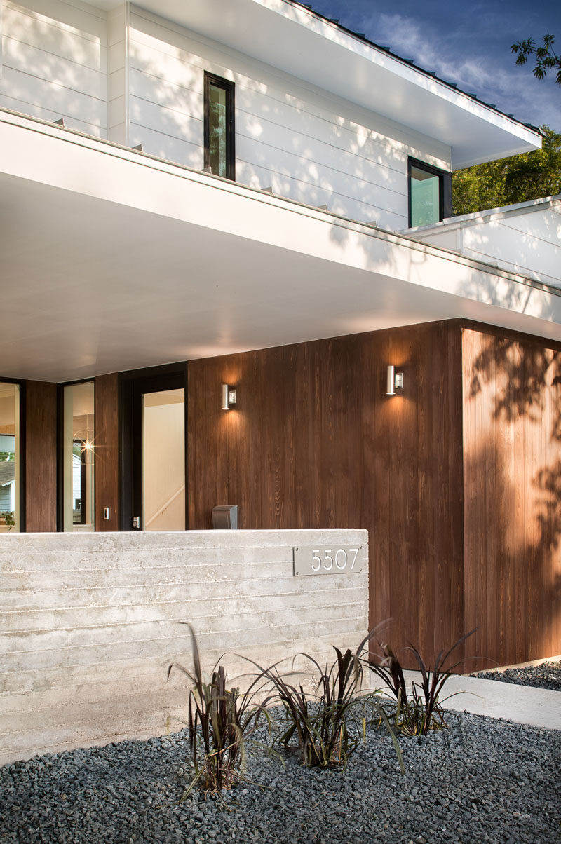 This modern house has a covered entry way that provides shelter when entering the front door. #ModernArchitecture #ModernHouse #WoodSiding