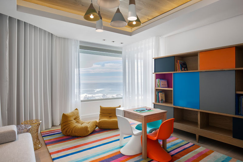 This kids playroom has a recessed ceiling that's highlighted by the use of wood and hidden lighting. #Playroom #ModernInteriorDesign