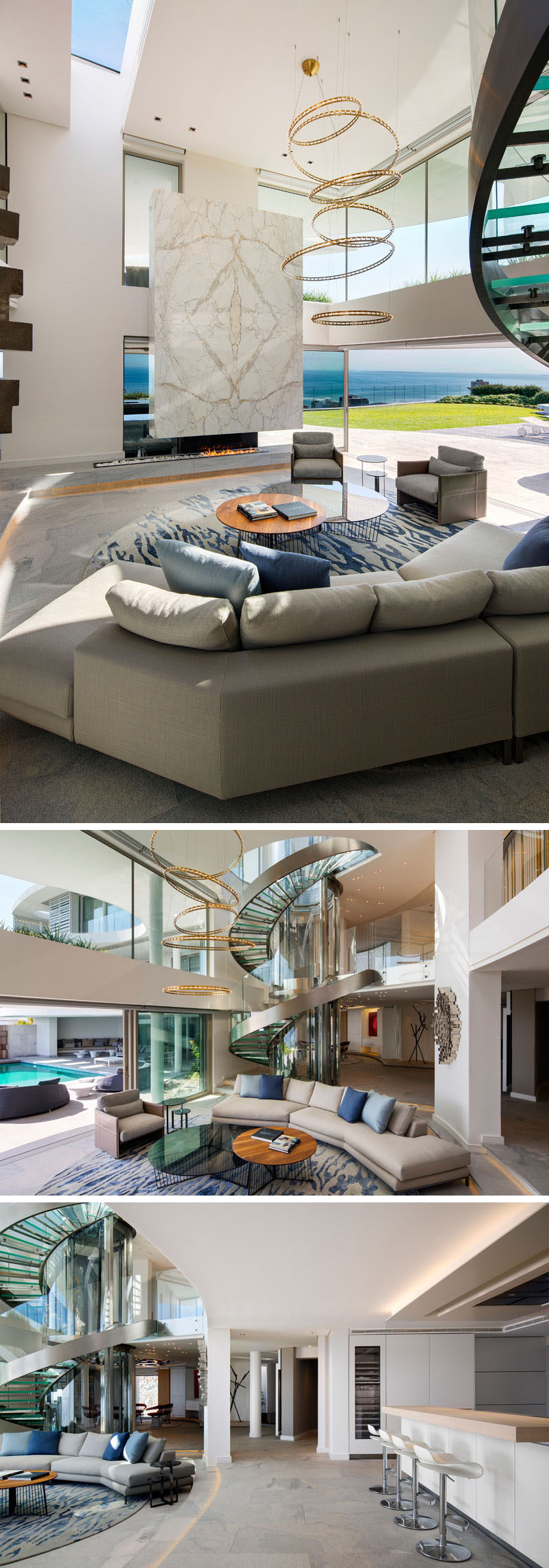 Inside this modern house, there's a living room with a double height ceiling. Throughout the interior, white marble, granite, brushed stainless steel and bronze elements have been included to contrast the white walls that are ever present throughout the house. #LivingRoom #ModernLivingRoom #InteriorDesign #SpiralStaircase