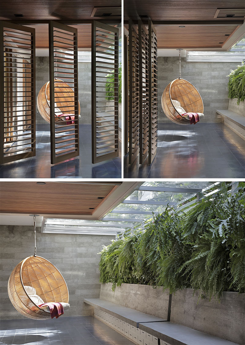 This modern outdoor space is separated into two areas, with wood louvre screens that can be pushed aside to open the space up or closed when privacy is required. The hanging chair is located off the master bedroom. #OutdoorSpace #HangingChair #LouvreShutters #SlidingShutters