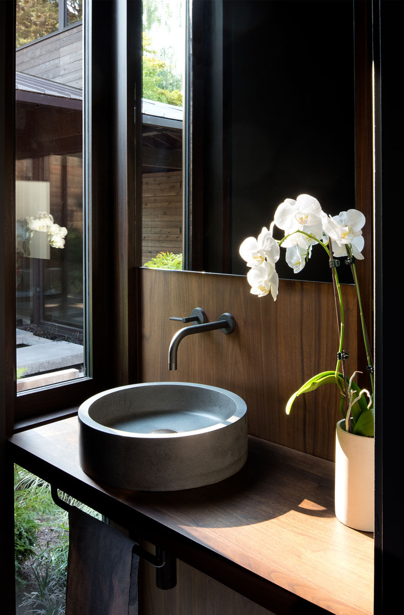 In this small powder room, there's a window with views of the courtyard from the vanity. #SmallBathroom #PowderRoom #Bathroom #Window