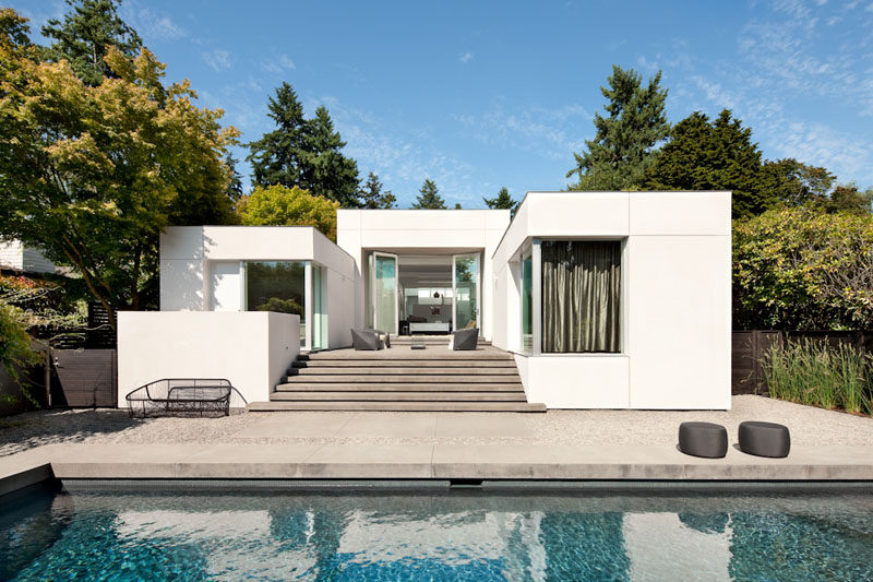 SkB Architects have updated an early 1990s house in Media, Washington, for their clients who wanted a gallery-like interior to highlight the owner's art collection. #Architecture #WhiteFacade #SwimmingPool #ModernHouse
