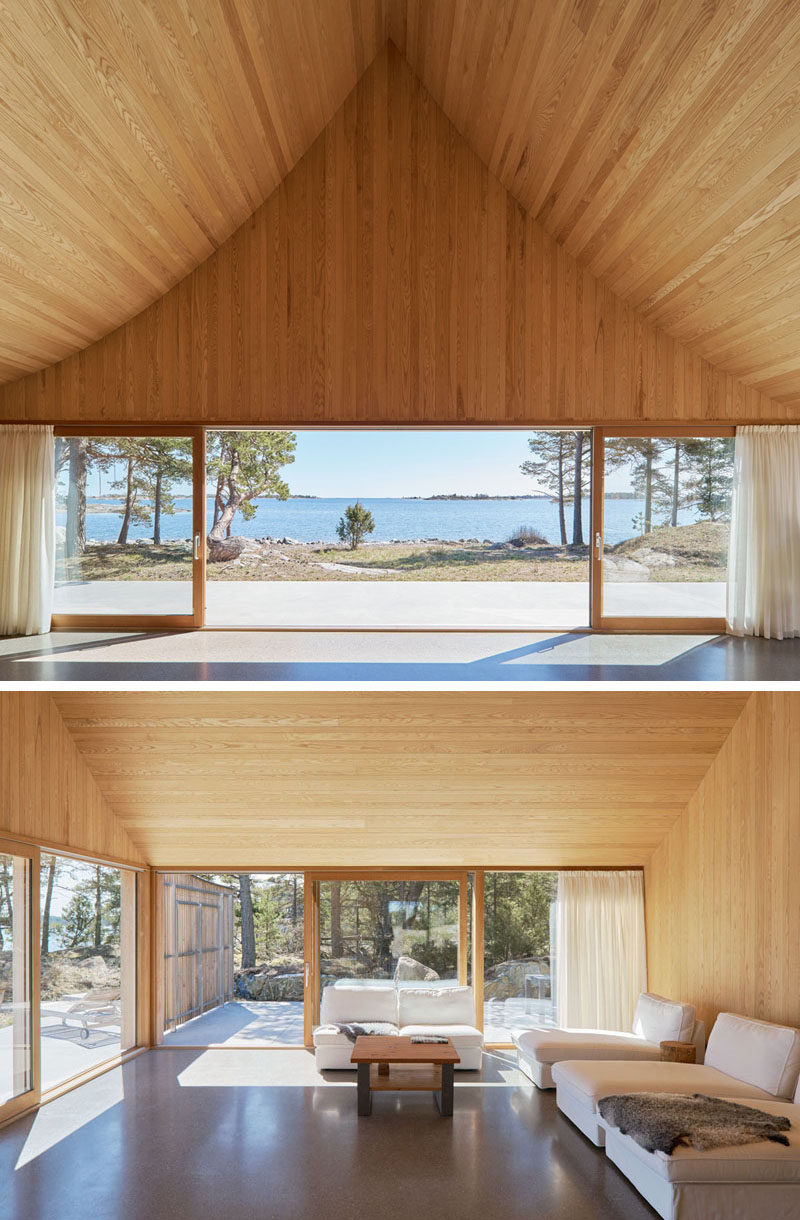 Cedar has been used to line the interior of this Scandinavian house, with the internal ridge of the ceiling measuring in at 18 feet (6m). In the living room, there's access to the front terrace as well as a side terrace for when it gets windy. #Architecture #Ceiling #InteriorDesign #LivingRoom #SlidingGlassDoors