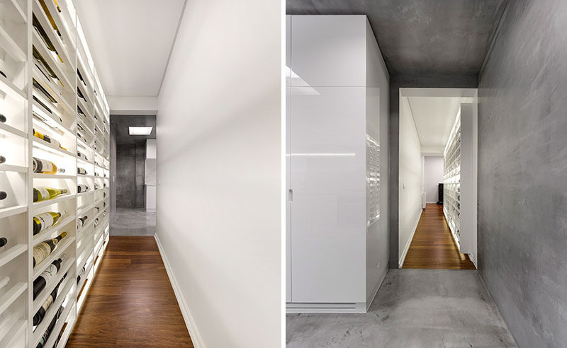 This modern apartment has a backlit wine wall in a hallway that connects the entrance hall to the kitchen. #WineStorage #WineWall