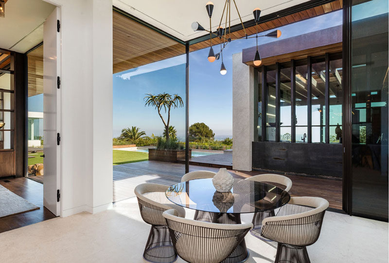 Large floor-to-ceiling windows in this contemporary dining room provide views of the backyard and add plenty of natural light to the space. #Windows #DiningRoom