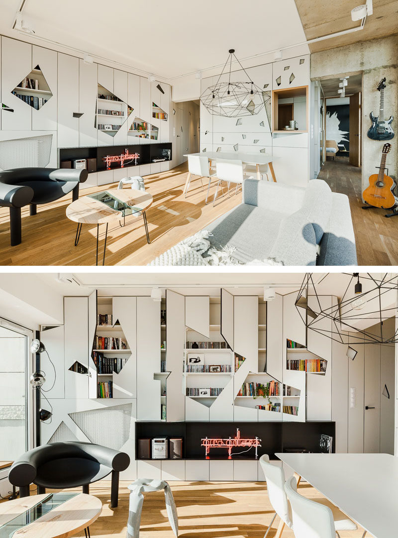 This modern apartment has a wall of white cabinets that have geometric cut-outs in the doors to add an artistic feature to the interior. #Cabinets #Geometric #LivingRoom #InteriorDesign #ModernLivingRoom