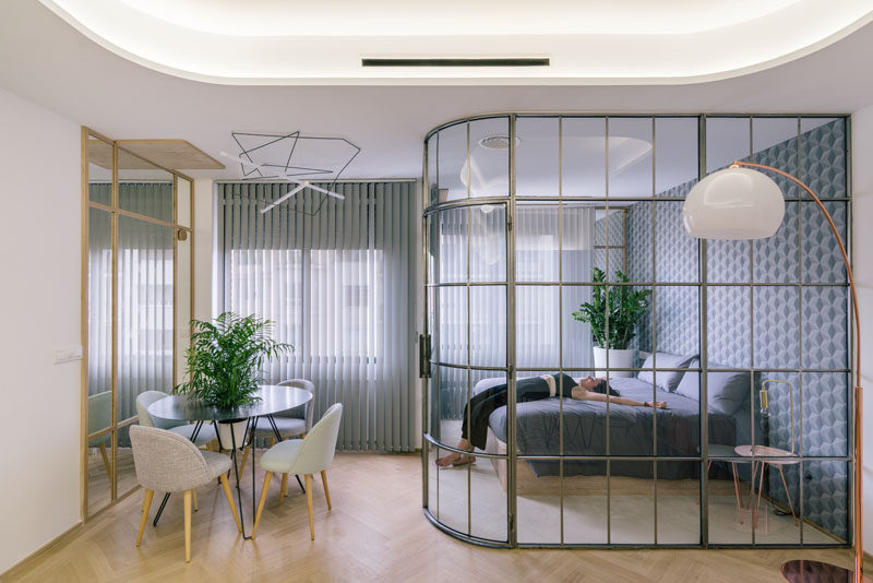 This modern bedroom is separated from the rest of the apartment by a framed glass wall. #GlassWall #BedroomDesign #FramedGlassWall #InteriorDesign #ModernBedroom