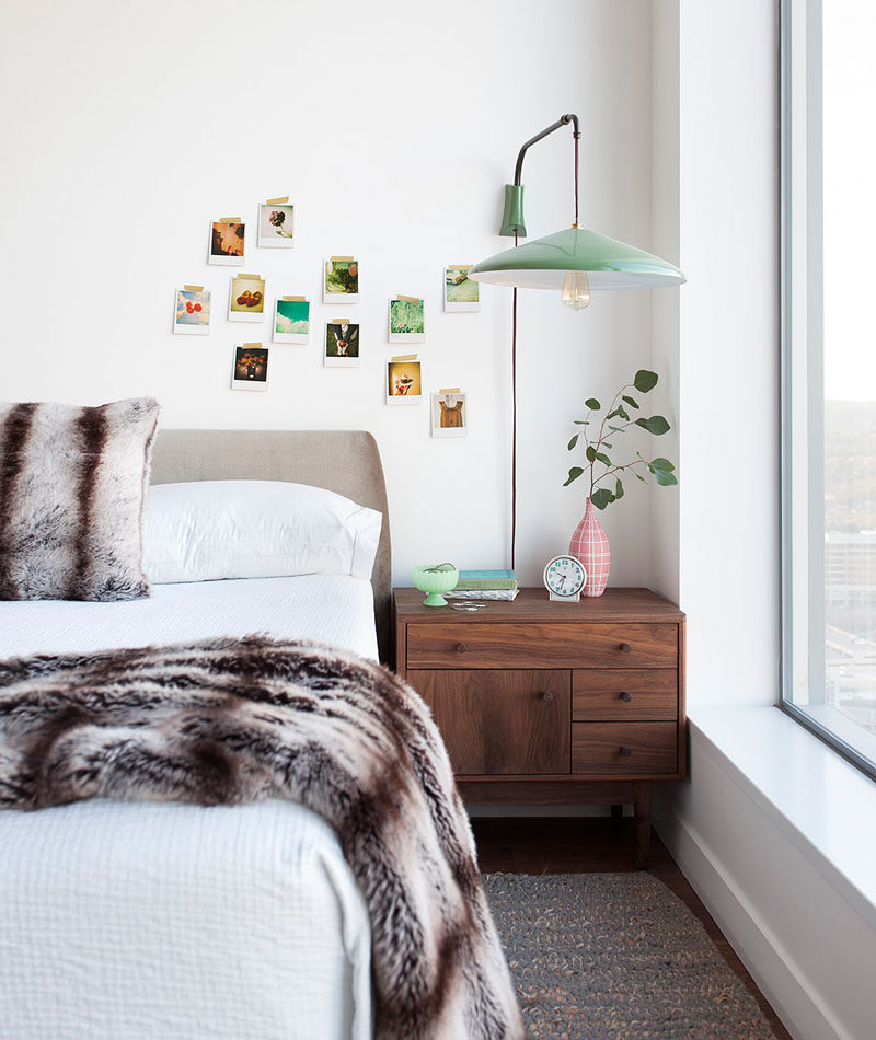 In this modern girl's bedroom, a pendant lamp attached to the wall hangs above a wood bedside table, while faux fur accents have been added to the bed. #BedroomDesign #ModernBedroom #InteriorDesign