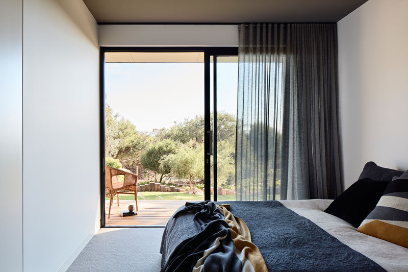 In this modern bedroom, a sliding glass door can be opened to have direct access to the backyard. #SlidingGlassDoor #Bedroom