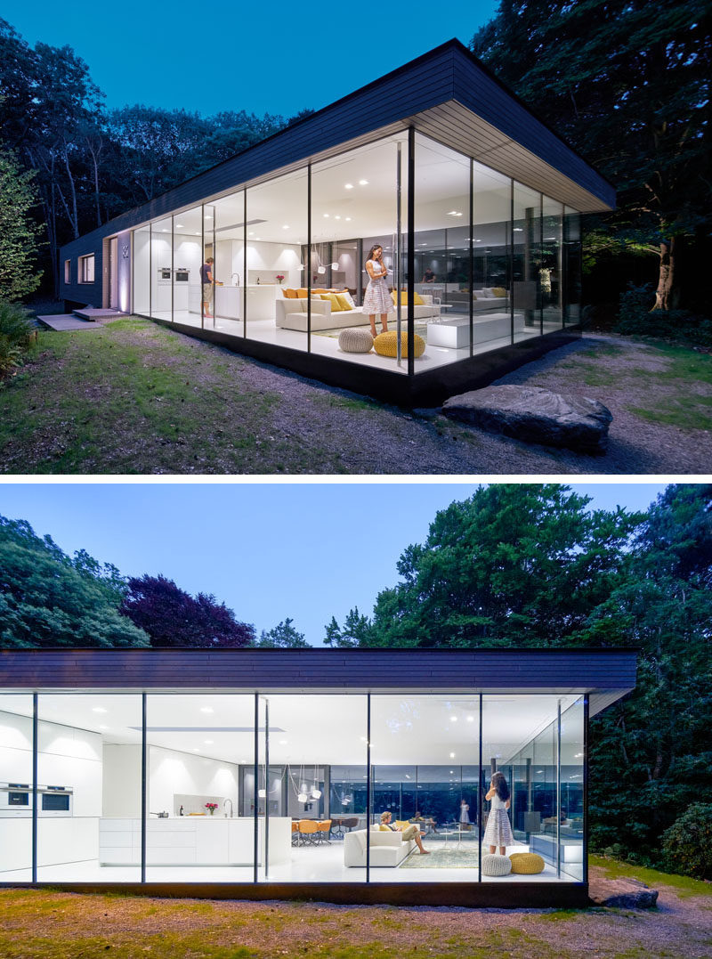 The main floor of this modern house has one end surrounded by glass on three sides, allowing the living room, kitchen and dining room to have views of the garden. #ModernHouse #Windows #GlassWalls #Architecture