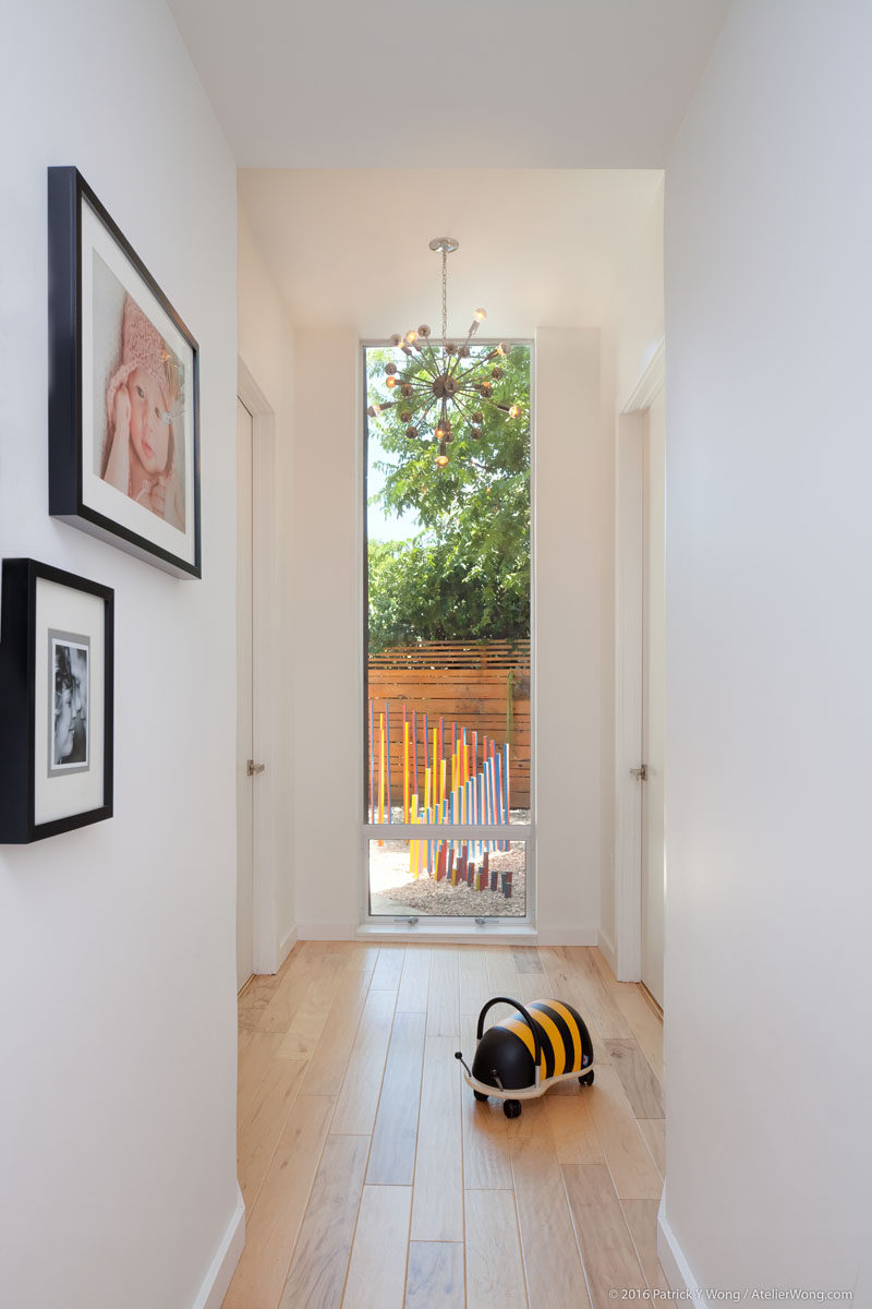 This small light-filled hallway provides access to the new bedrooms and gives a glimpse of the sculpture garden outside. #Hallway #Windows