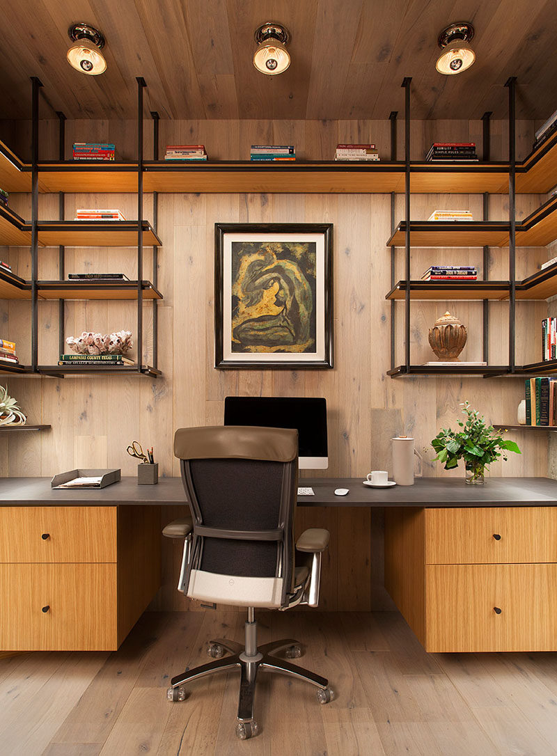 This modern home office is lined with wood and has steel and wood open shelving. #HomeOffice #InteriorDesign #Shelving