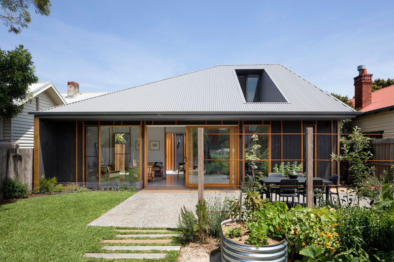 In the backyard of this modern house, there's a large patio area with an outdoor dining table and plenty of space for gardens. #Landscaping #Backyard #Patio