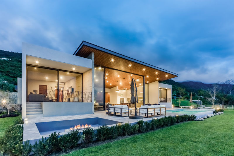 FARQ Arquitectos have designed a new house in Jocotepec, Mexico, that sits on a sloped site and features high ceilings, open spaces and lake views. #ModernHouse #Mexico #SunkenFirepit #WoodCeiling #ModernArchitecture