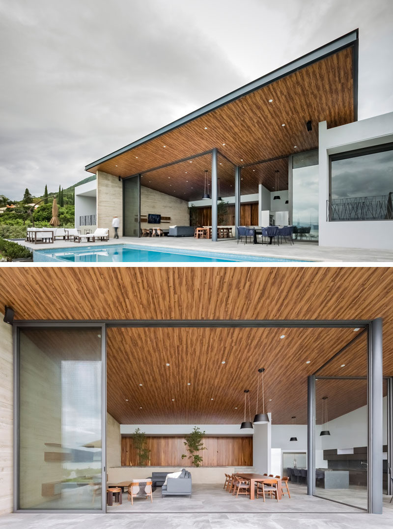 This modern house has large sliding glass walls that can be opened to create a true indoor / outdoor living environment, and the large overhanging wood ceiling flows seamlessly to the outside. #ModernHouse #ModernArchitecture #WoodCeiling #SlidingGlassWall