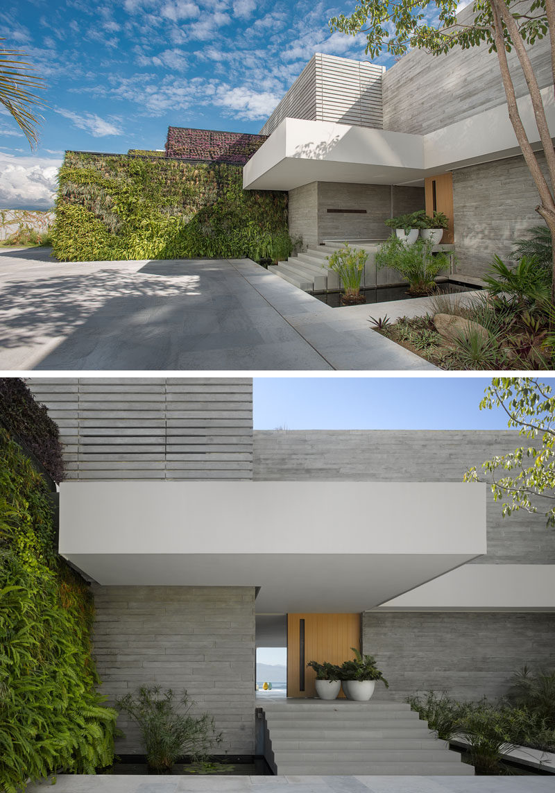 Welcoming you to this modern house is a green wall and water features, while steps lead to the wood front door. #GreenWall #WaterFeature #Steps #FrontDoor #Architecture