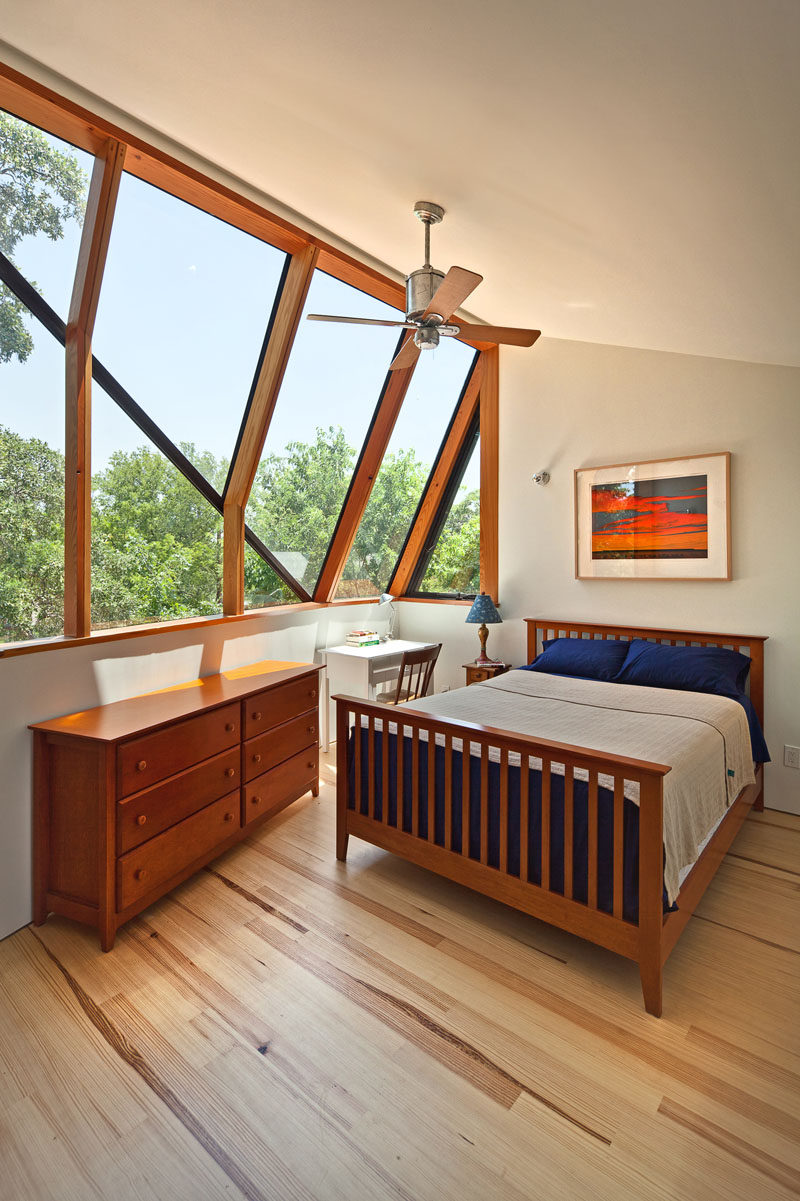 This master bedroom suite has large angled windows that look out to the old oak tree and provide views of the neighborhood. #Windows #Bedroom #AngledWindows