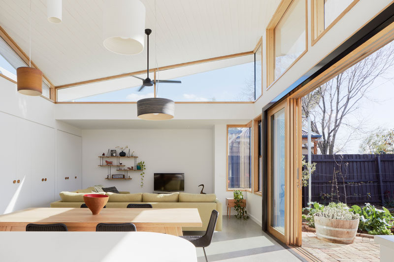 This sculptural roof sits over the extension and twists symmetrically around a central ridge. Clerestory windows follow the roof line allow sunlight to enter the interior from all sides. #ModernHouseExtension #Windows #Architecture