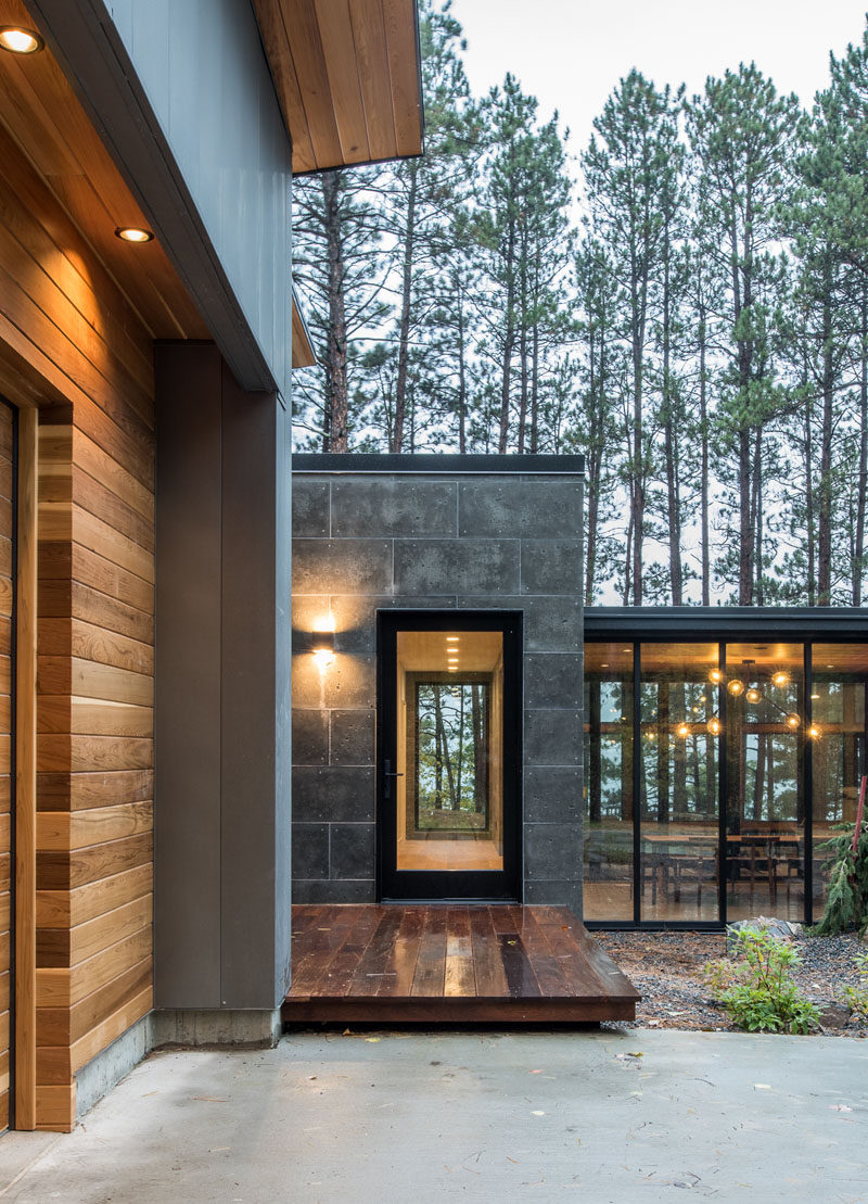 This modern house has a subtle dark exterior that includes grey, black, stone and wood elements, allowing the home to blend into the forested landscape. #ModernHouse #Wood #Grey #Stone