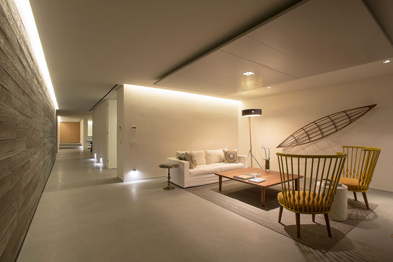 Stepping inside this modern house, the interiors are inspired by the beach houses of California. Colors and textures like linen provide the comfort while wooden furniture and vintage accessories adding elements of the fifties. #ModernHouse #InteriorDesign #SittingRoom #Hallway