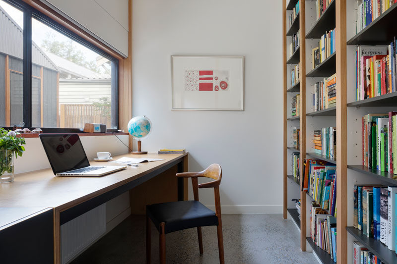 This home office has a wall full of shelving for books and a window that looks out onto a courtyard. #HomeOffice #Study #Bookcase #Shelving