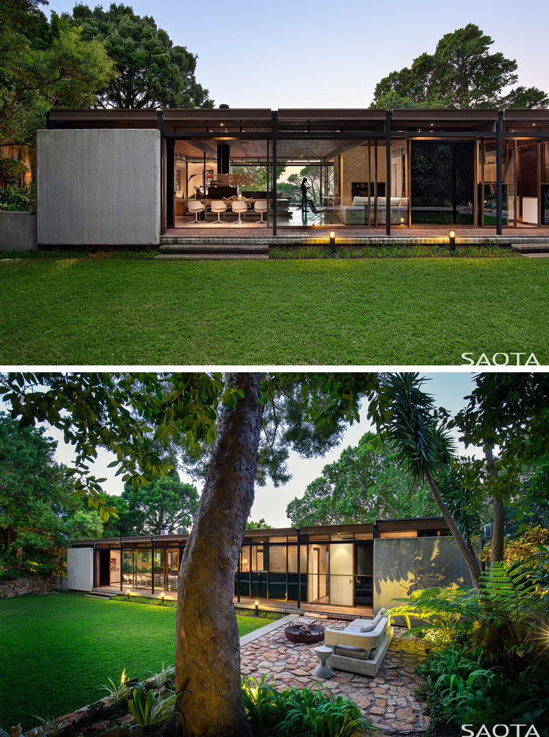 This modern house has a large lawn and a outdoor lounge area that's designated by the use of stone. #Backyard #OutdoorLounge