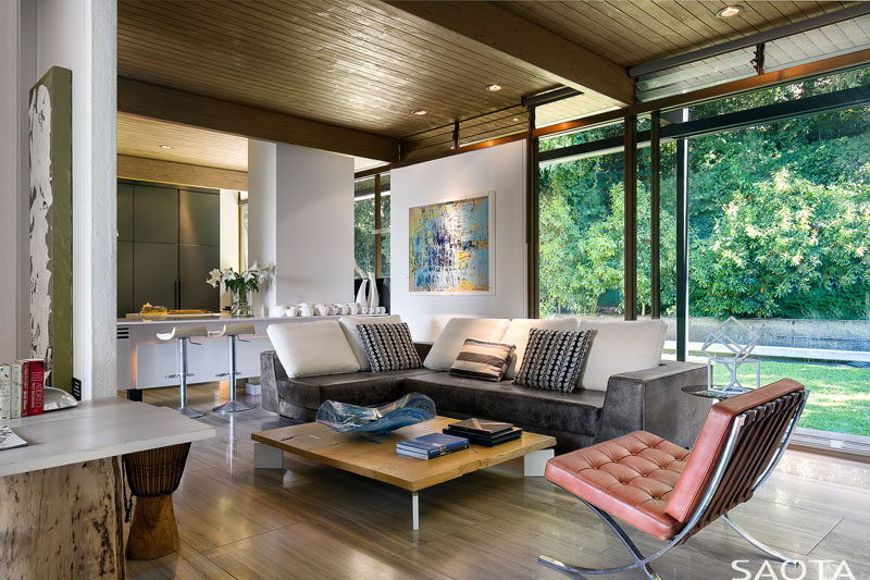 This modern house has a sitting area next to the kitchen and it opens up to the backyard. #SittingArea #LivingRoom #WoodCeiling