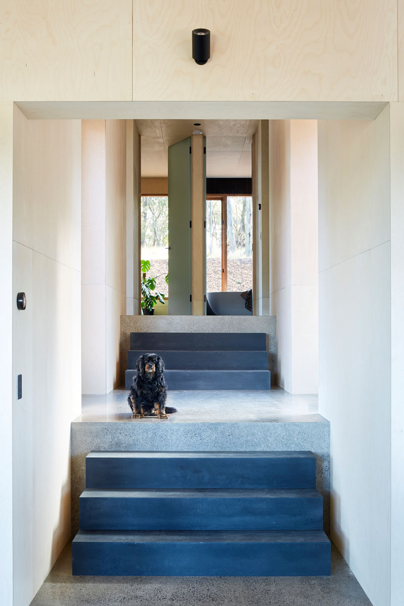 A set of stairs in this modern house leads up to the second half of the home that houses the bedrooms and bathrooms. #ModernStairs #StairDesign