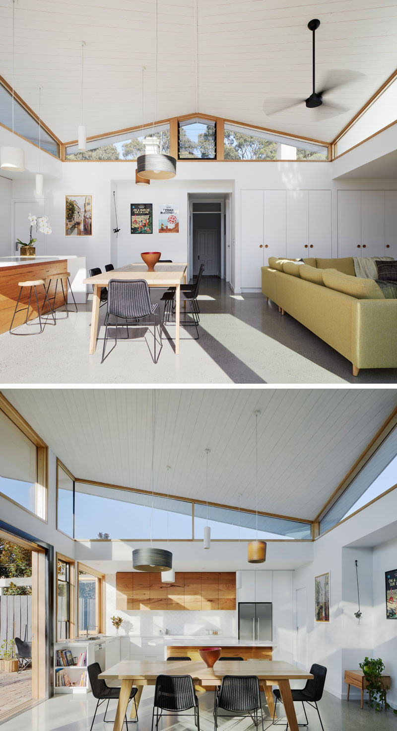 Inside this modern house extension, there's a white timber ceiling that compliments the walls and built-in storage cabinets, and is used to create a sense of lightness to the space. #HouseExtension #Windows #Architecture