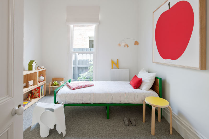 A colorful green bed and bright artwork helps to define this modern child's bedroom. #KidsRoom #KidsBedroom #InteriorDesign